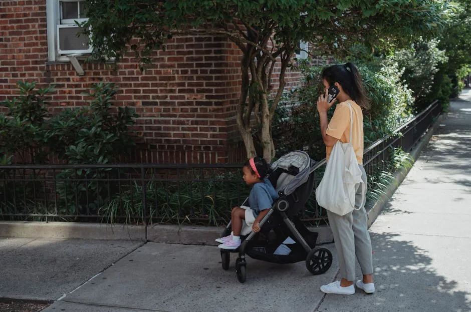 Adorable baby peacefully sleeping in a stroller, wearing a striped onesie.
