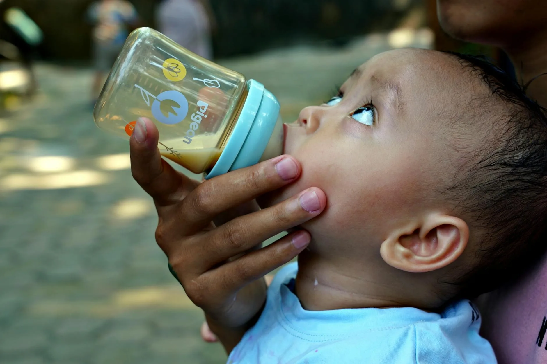 Baby being fed with a bottle in a nursery setting