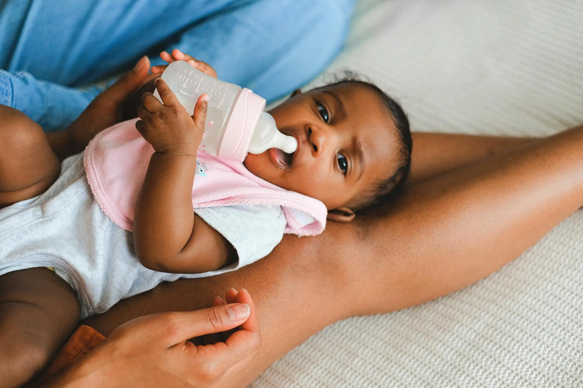 Baby drinking milk from a bottle during feeding