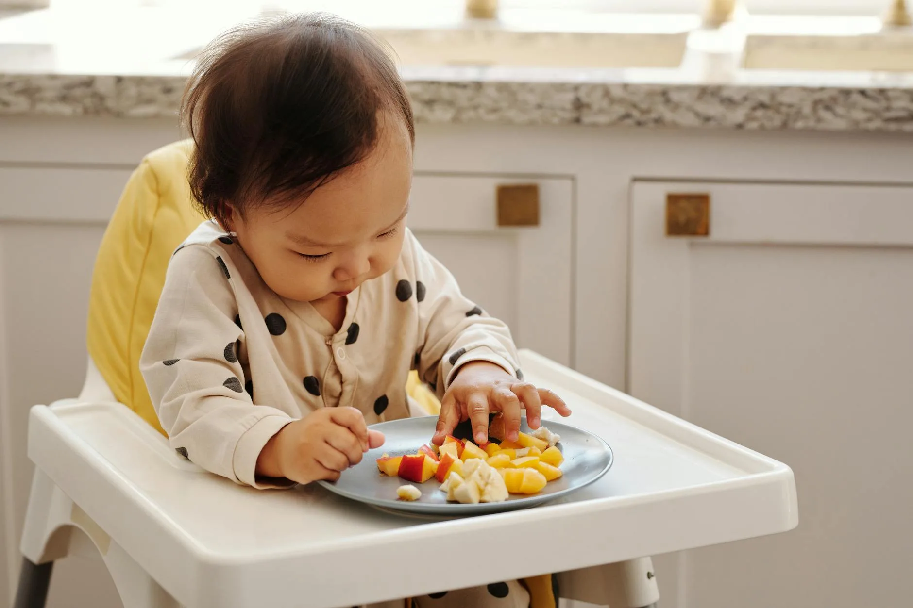 Baby finger foods including broccoli and banana on a plate