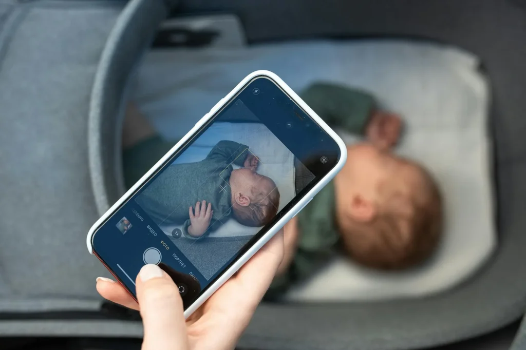 Baby monitor camera mounted near a cot in a nursery