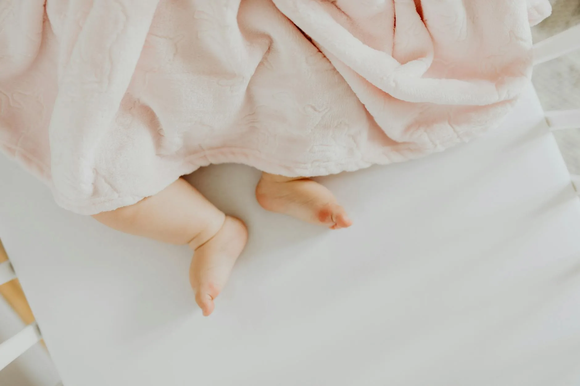 Baby sleeping peacefully on a firm cot mattress