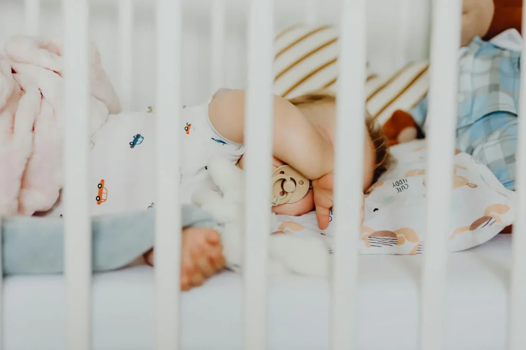 Baby sleeping peacefully in a cot in a softly lit nursery