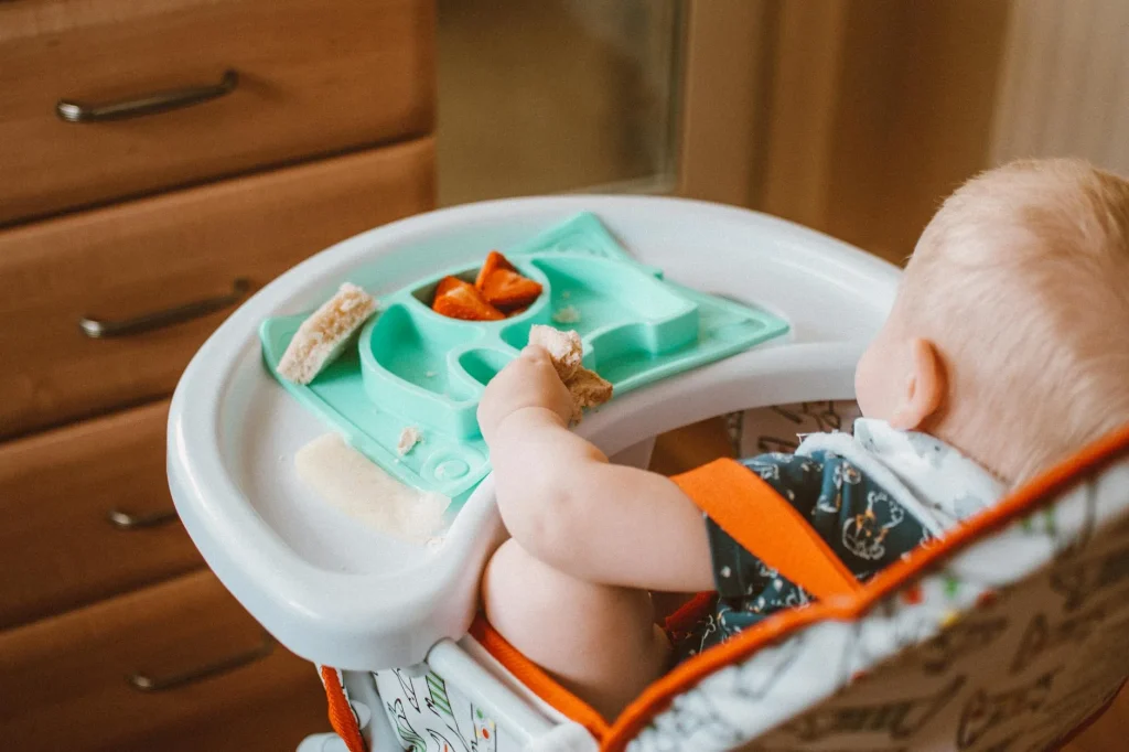 Baby sitting in a highchair during mealtime in a kitchen