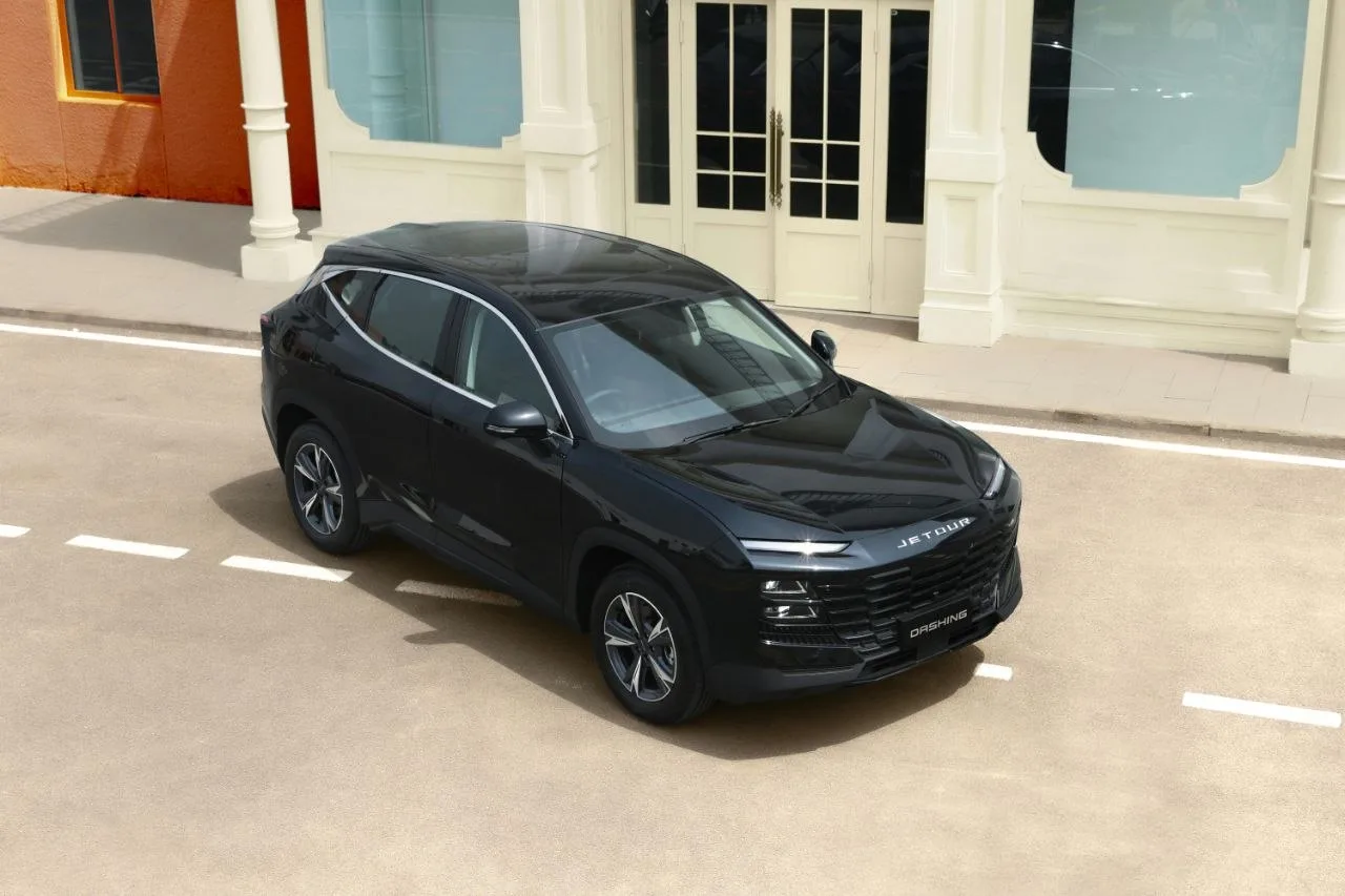 Black SUV parked on a city street with buildings behind