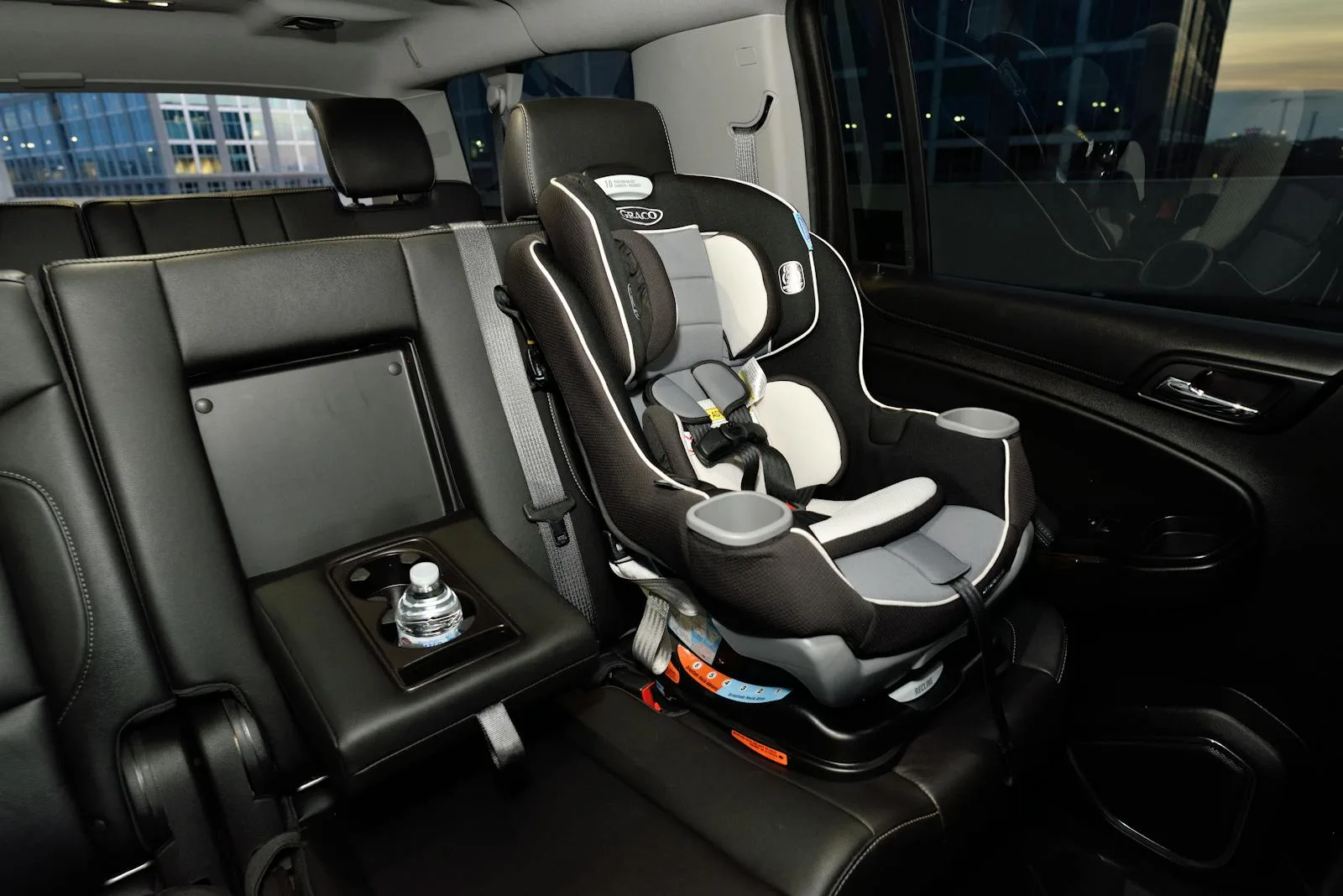Child car seat with harness properly installed in the back seat of a car