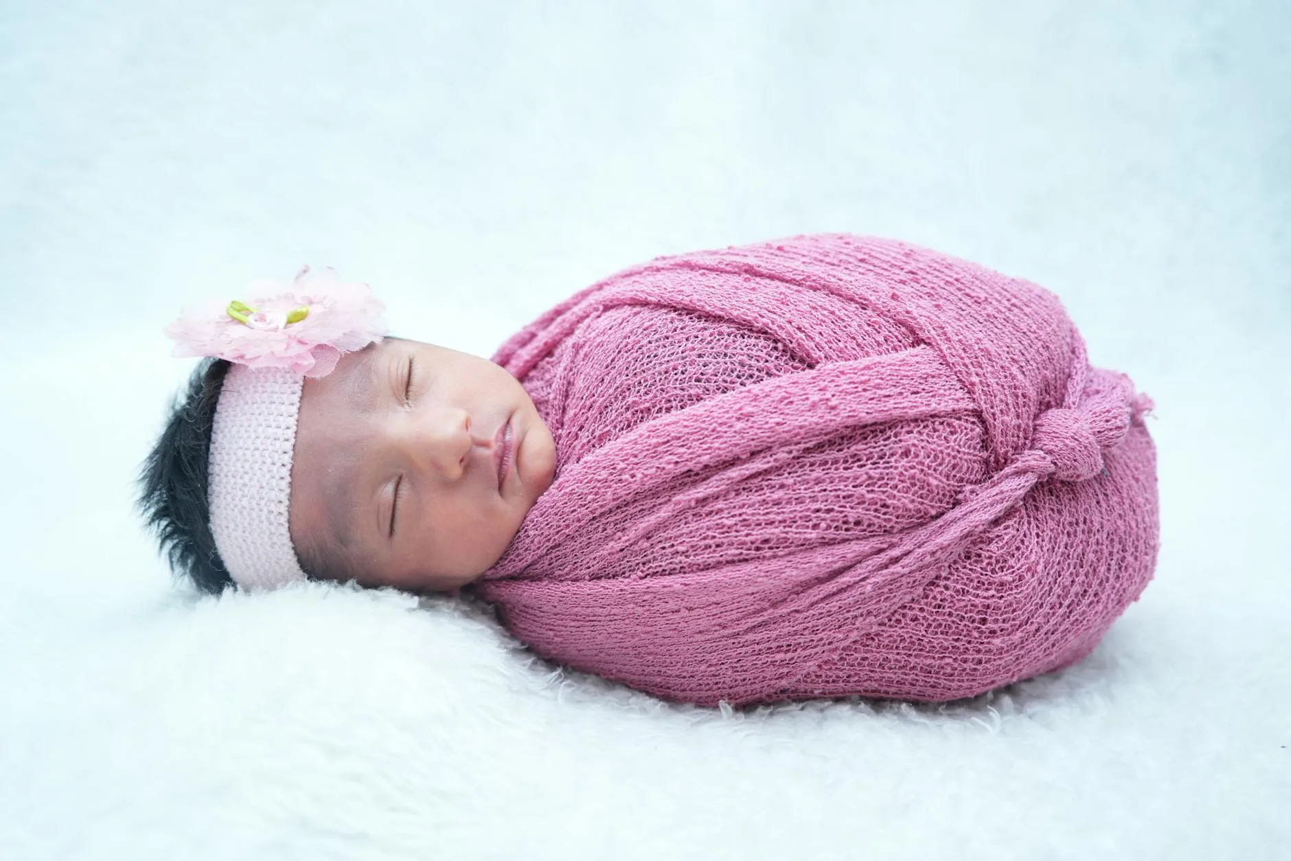 Infant wearing a sleeping bag for safe crib sleep