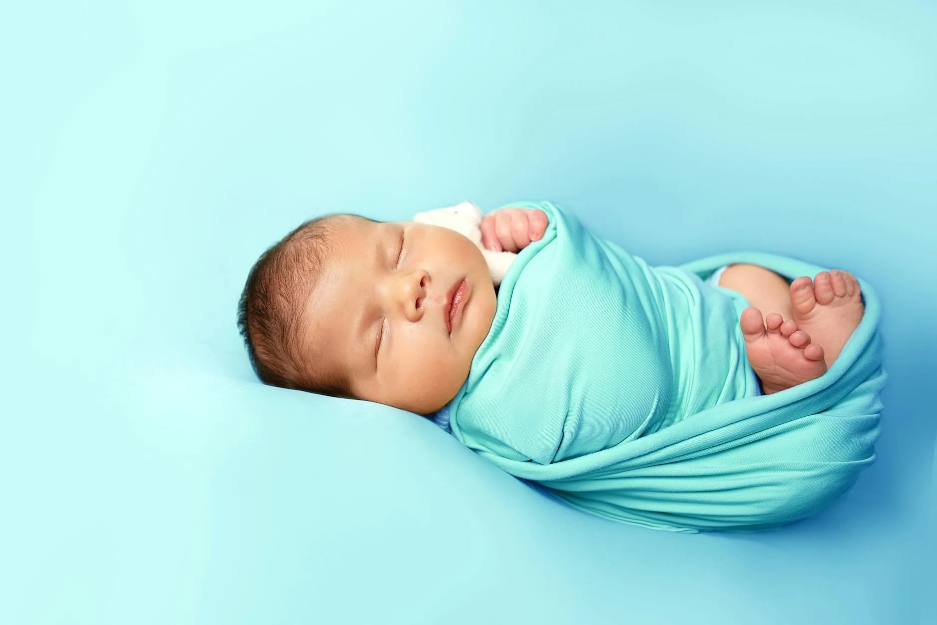 Newborn baby swaddled in a blanket sleeping calmly