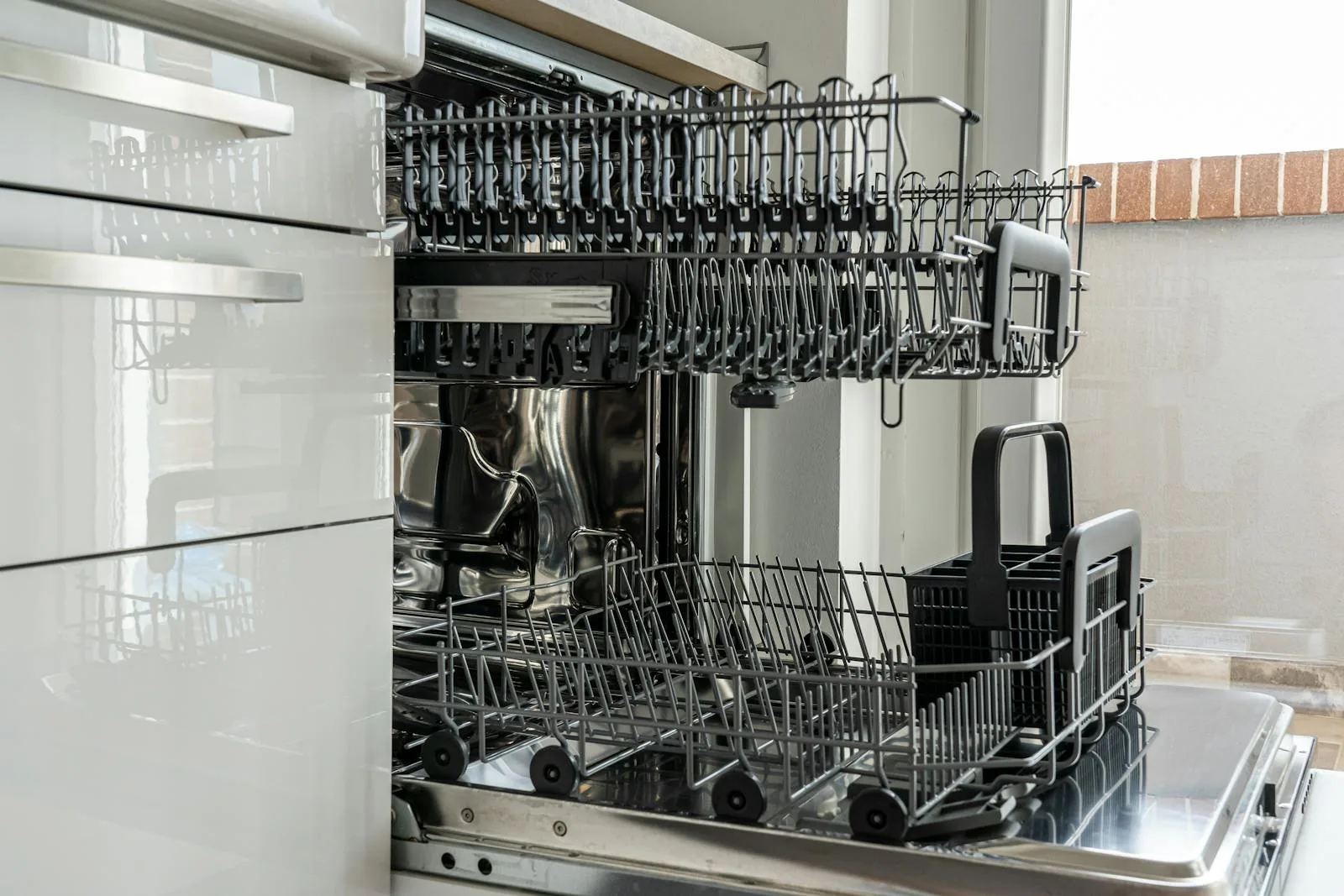 Open dishwasher with clean racks in modern kitchen