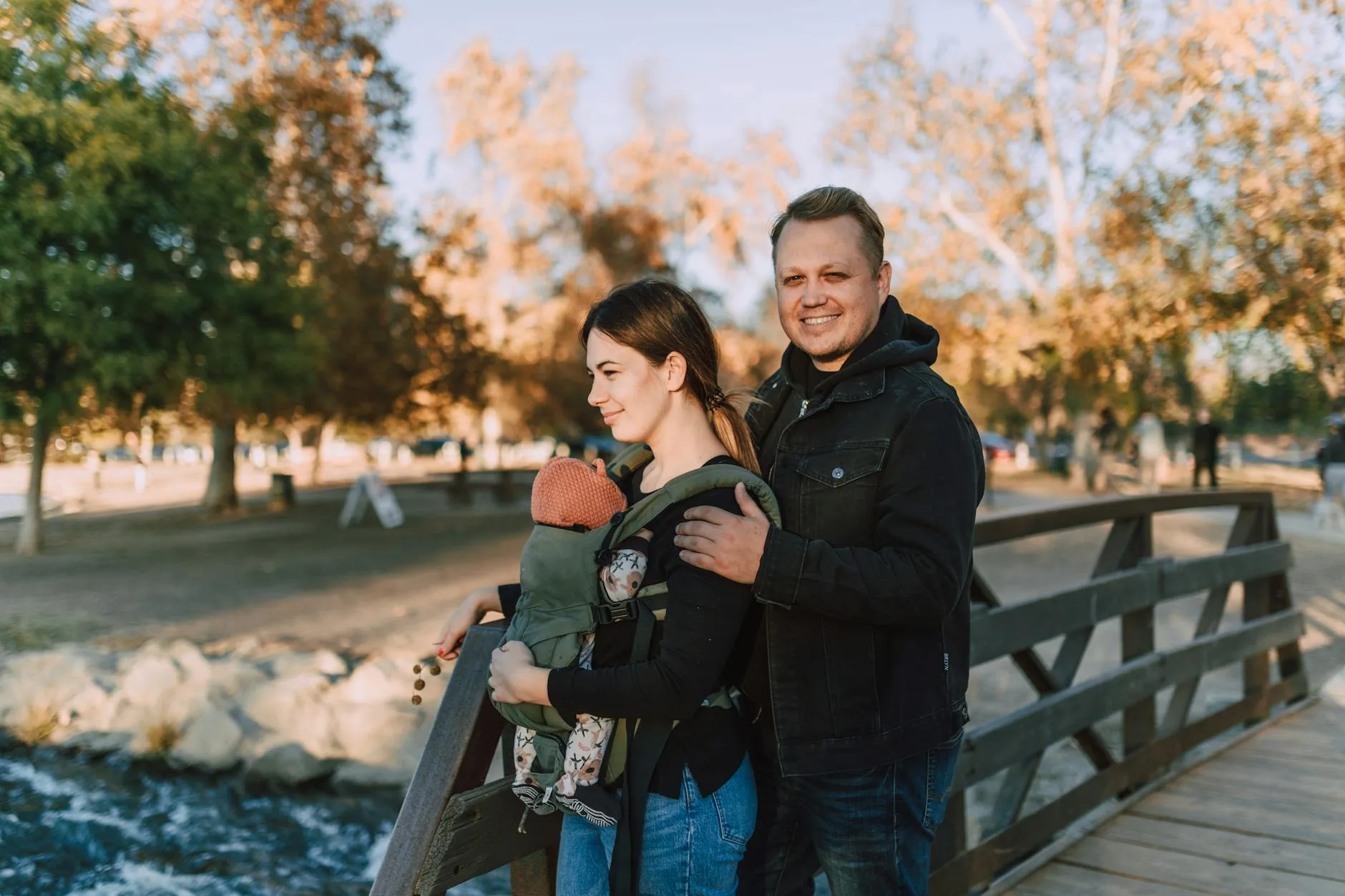 Parent carrying baby in a structured carrier while hiking outdoors