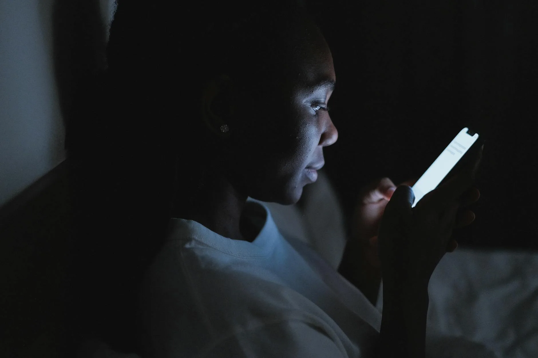Parent checking a baby monitor app on their smartphone at night