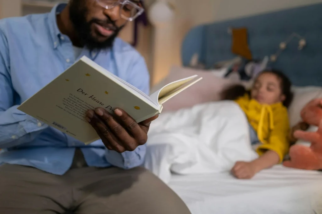 Parent reading bedtime story to child in cosy bedroom