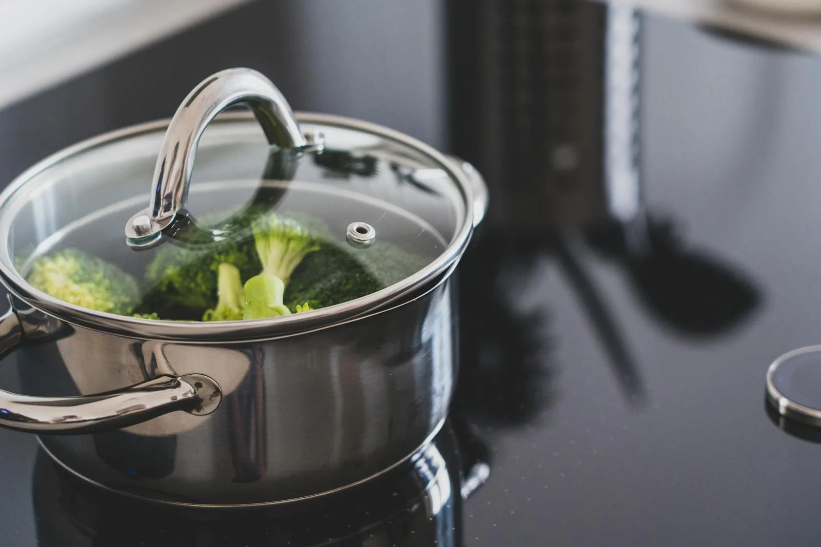 Stainless steel pot with lid on stove for boiling baby bottles
