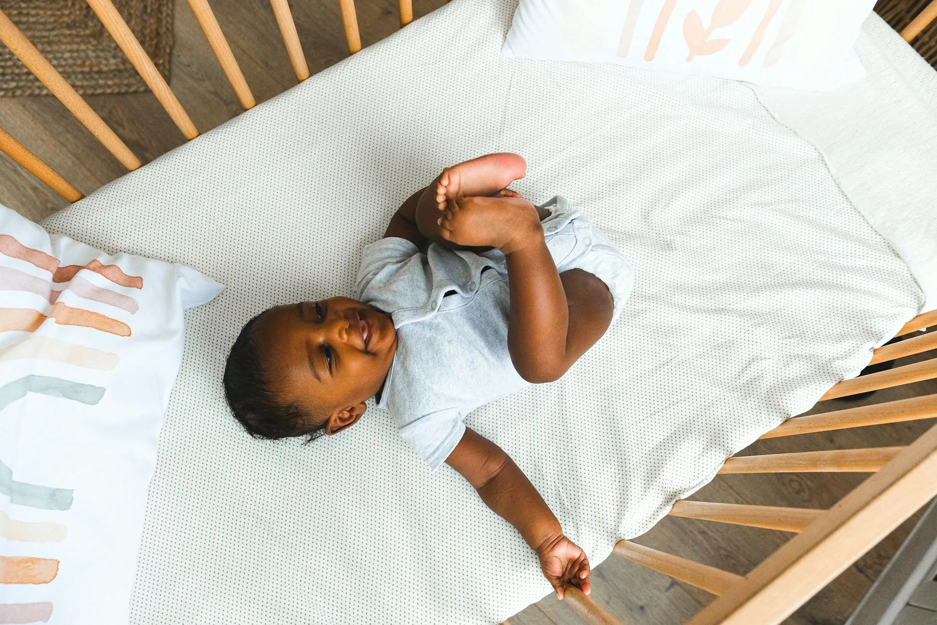 Overhead view of a baby crib in a softly decorated nursery room