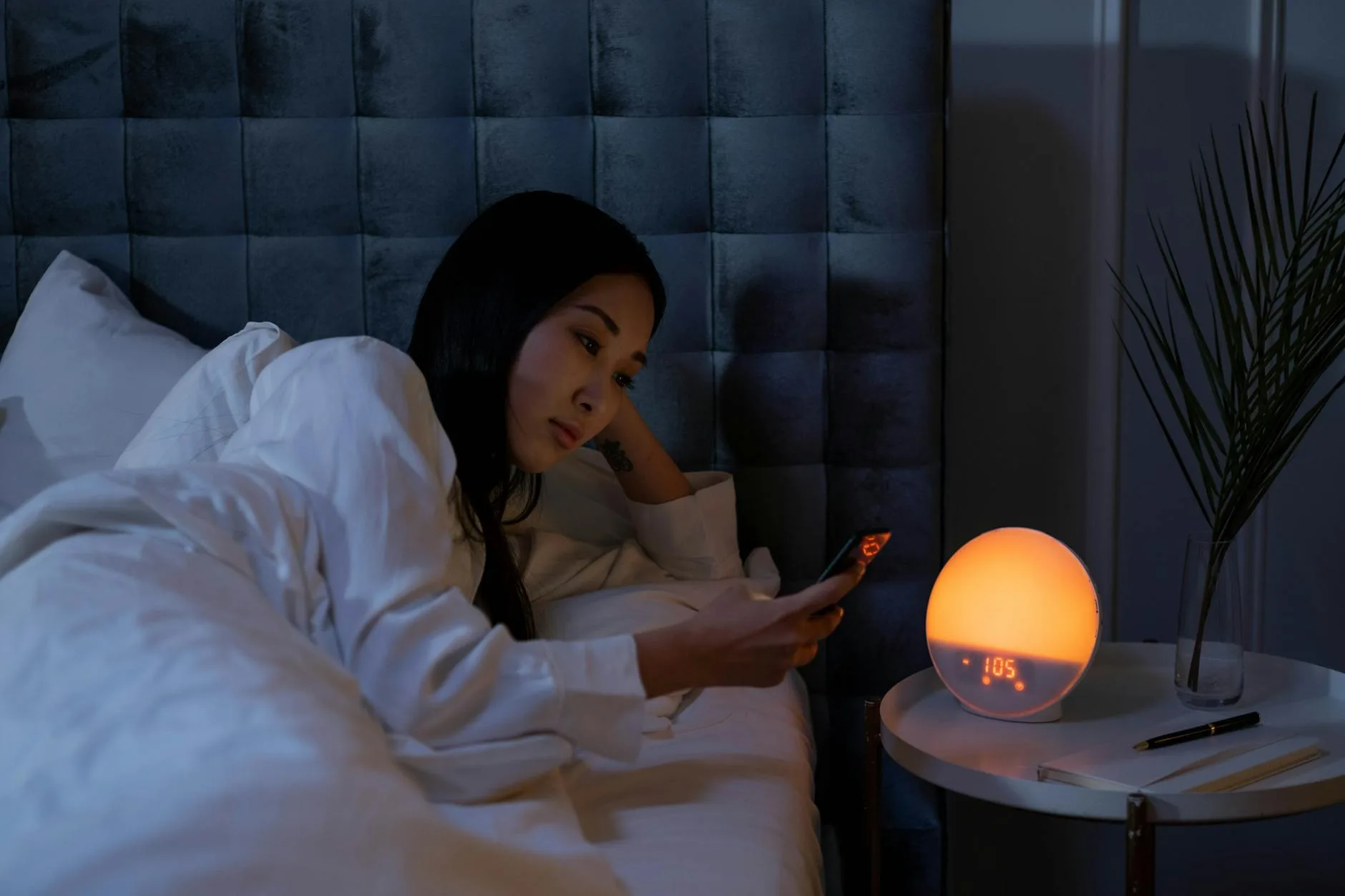 Smartphone on a nightstand in a dimly lit bedroom