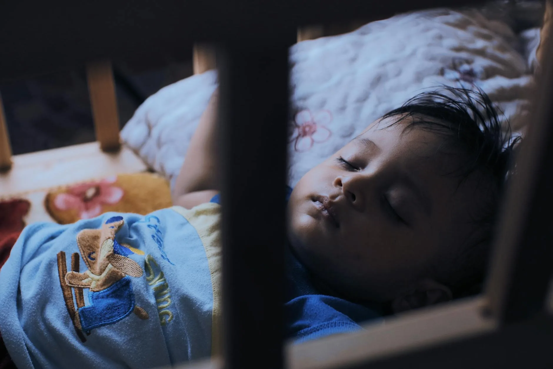 Toddler sleeping cosily in a crib at night