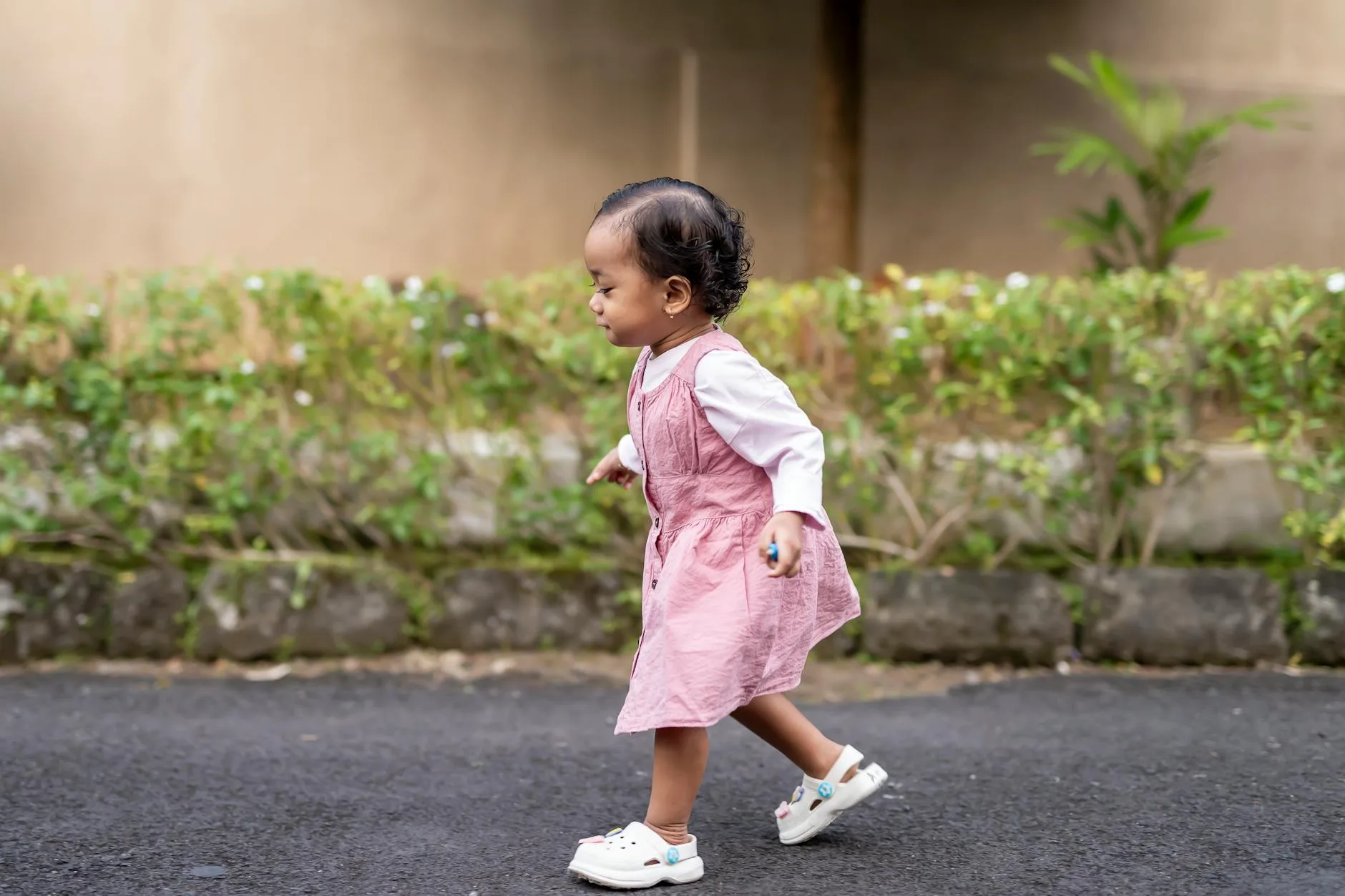 Toddler walking independently outdoors in a park