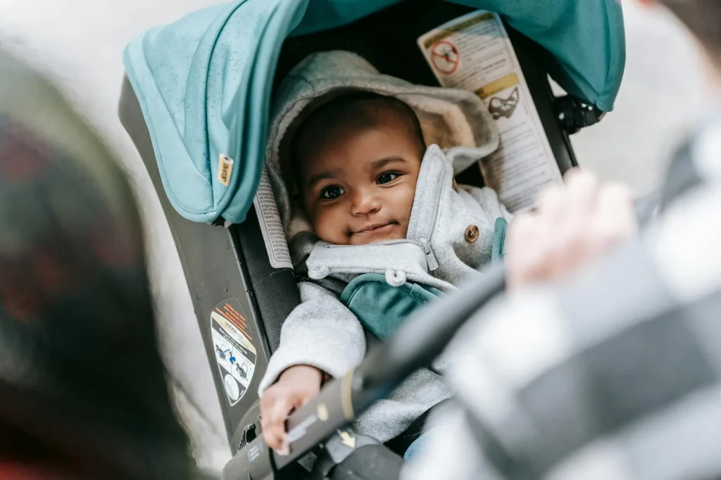 Baby secured with harness straps in a car seat