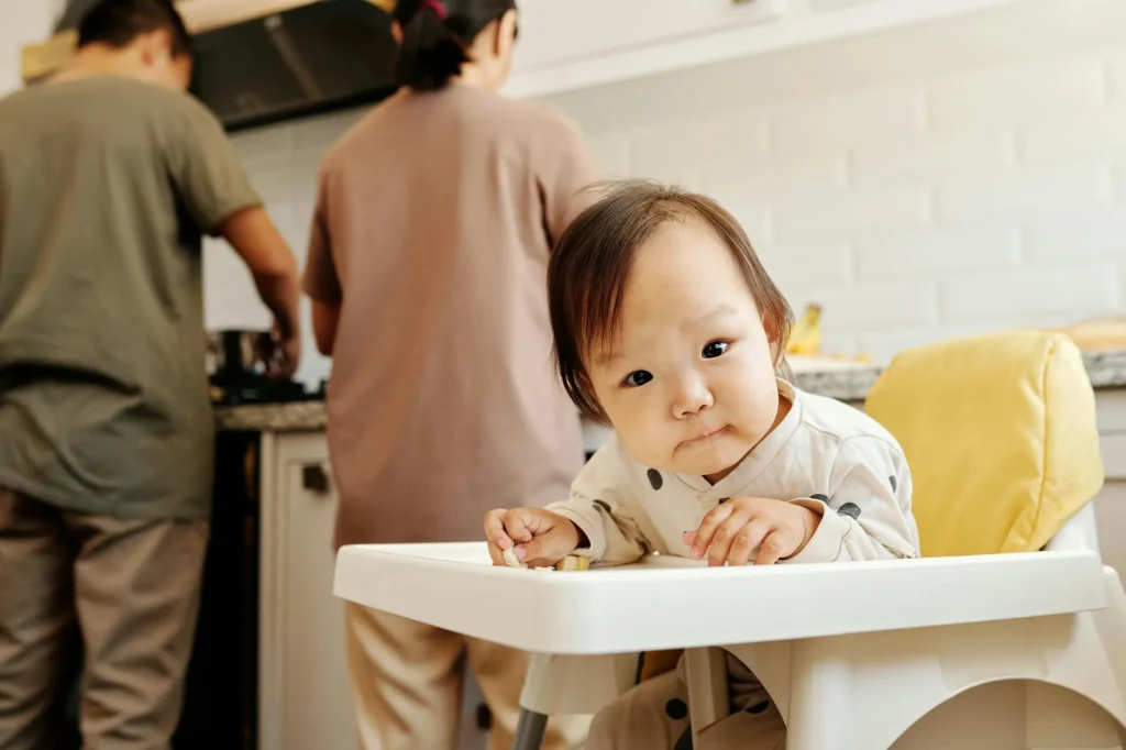 Baby eating first foods in a highchair