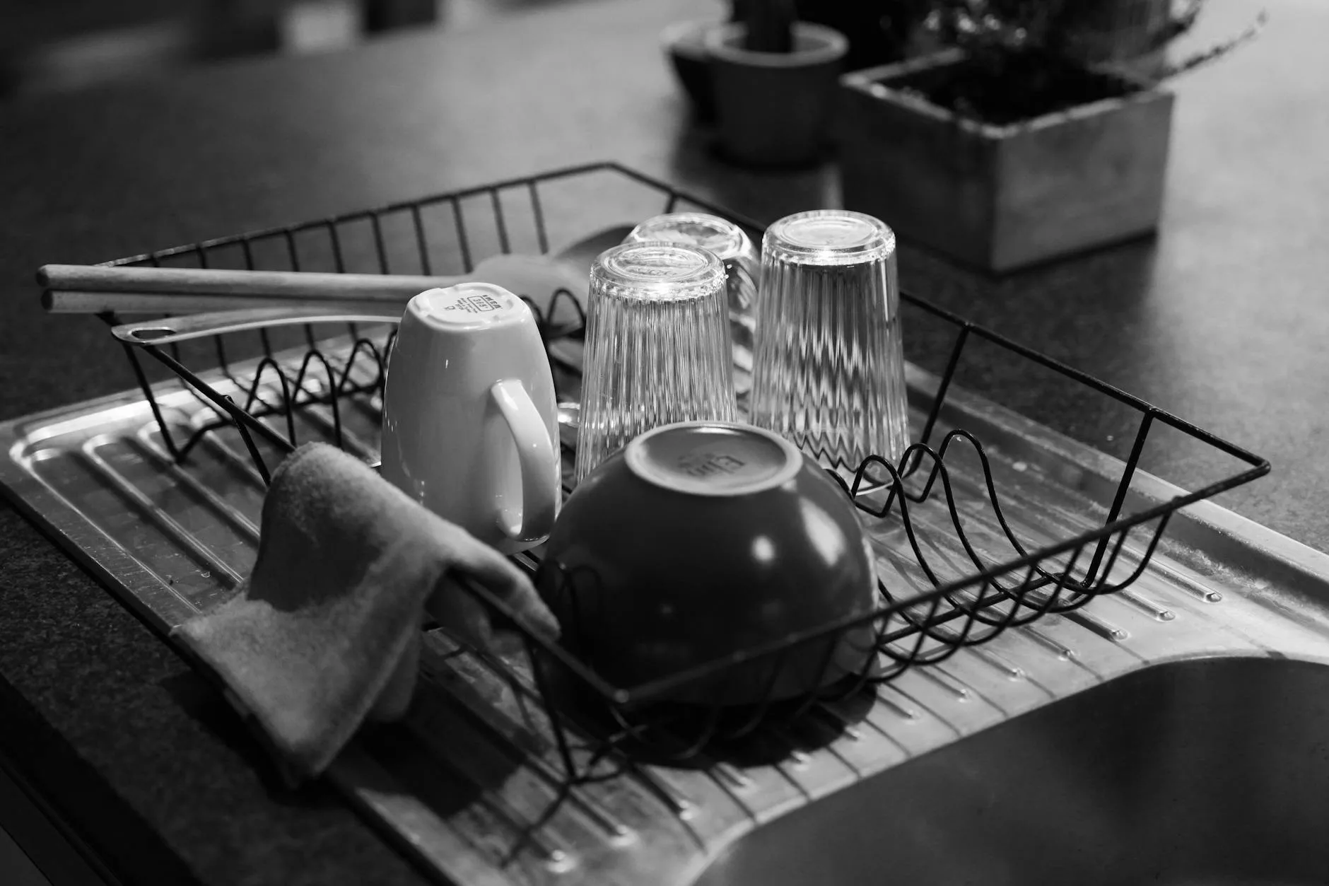 Baby cups and bottles drying on a kitchen rack