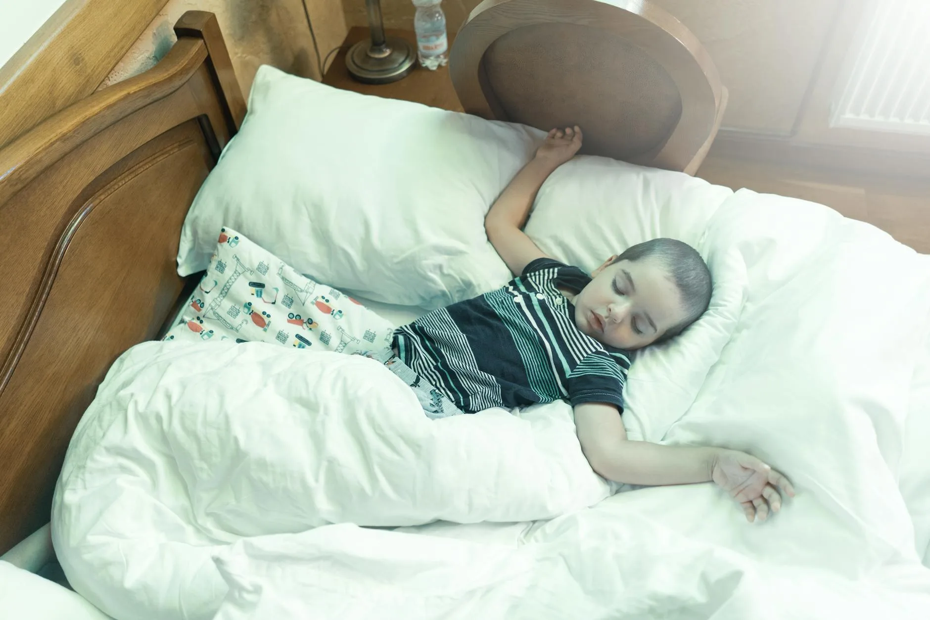 Child sleeping peacefully in a dimly lit bedroom
