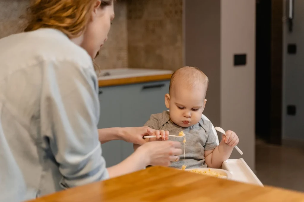 Baby exploring soft finger food in a highchair during weaning